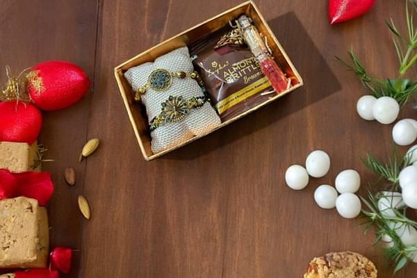 Nirmalaya Bhaiya Bhabhi Rakhi Set With Roli Chawal & Almond Brittle Brownie image